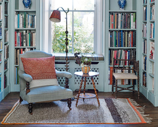 cozy reading nook with a comfortable armchair, a bookshelf filled with books, and a lamp casting a warm glow.
